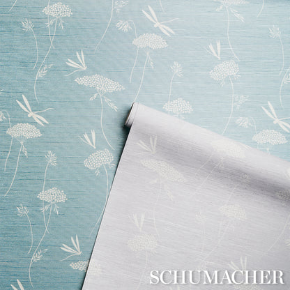 Light blue grasscloth wallpaper with a silk texture; rolled sheet partially unrolled.