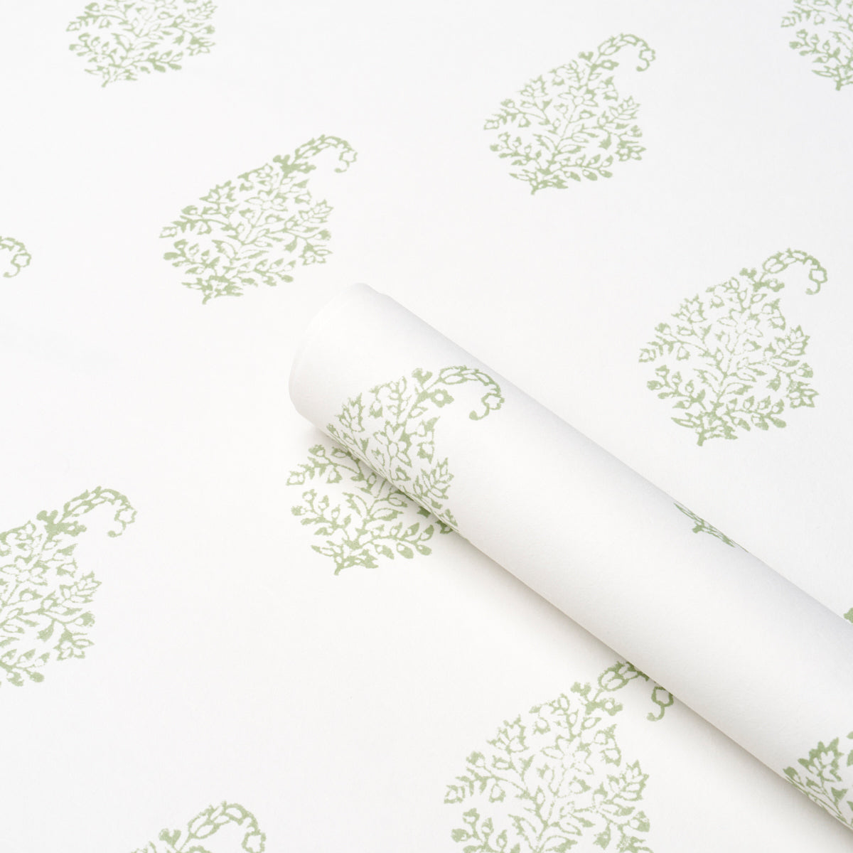 White wallpaper with a pale green paisley leaf pattern, rolled up at the corner.