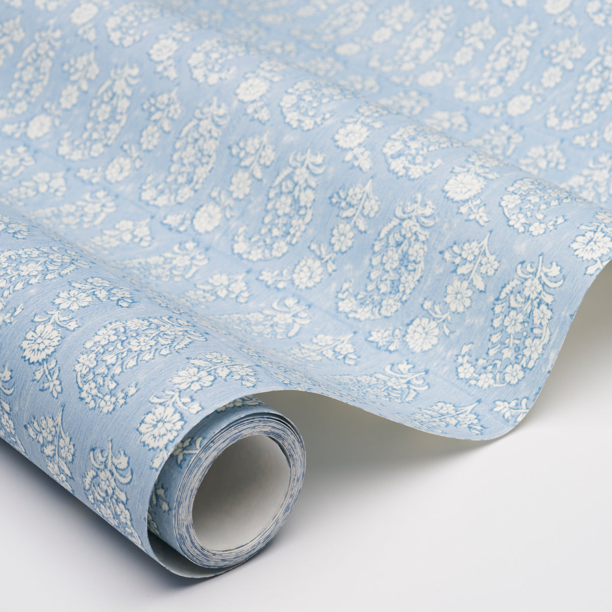 Light blue jacquard fabric with white floral damask pattern, rolled up, ideal for drapery or upholstery.