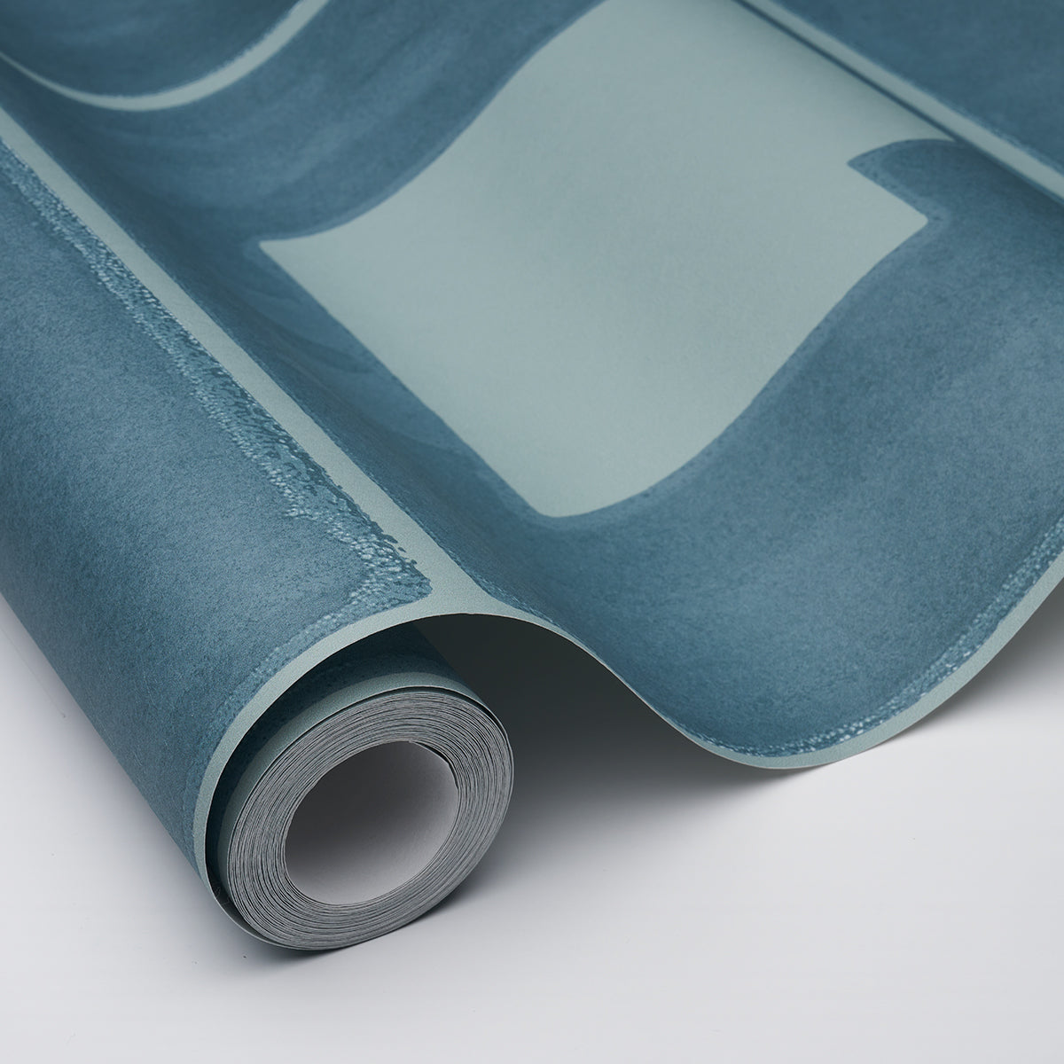Teal blue glossy vinyl wallpaper roll, curled edge reveals a smooth sheet and backing.