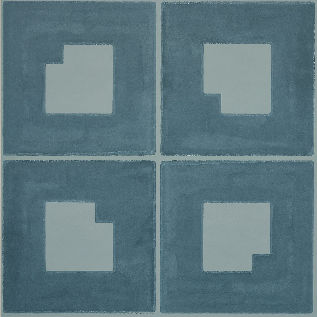 Four blue square tiles with pale gray inset shapes forming a stepped square pattern; modern geometric floor decor.