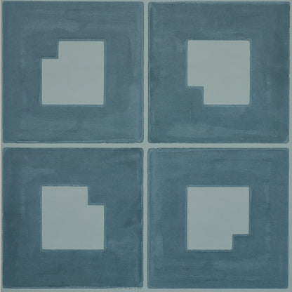 Four blue square tiles with pale gray inset shapes forming a stepped square pattern; modern geometric floor decor.
