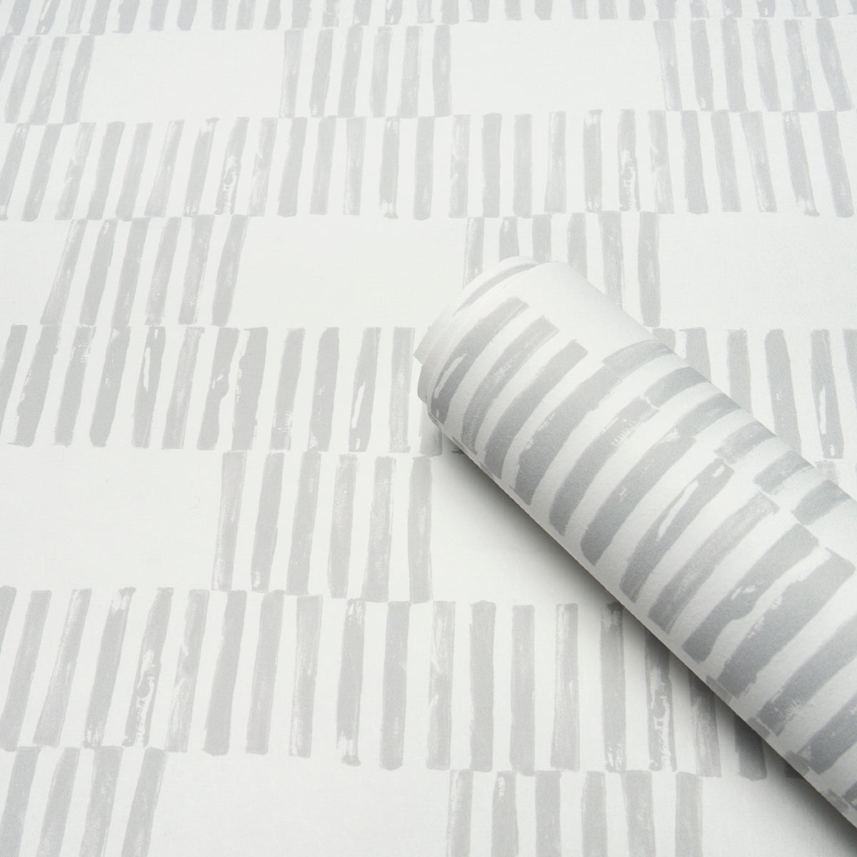 Roll of wallpaper with light gray vertical brushstroke stripes on white background; modern decor pattern.