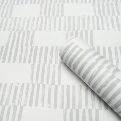 Roll of wallpaper with light gray vertical brushstroke stripes on white background; modern decor pattern.