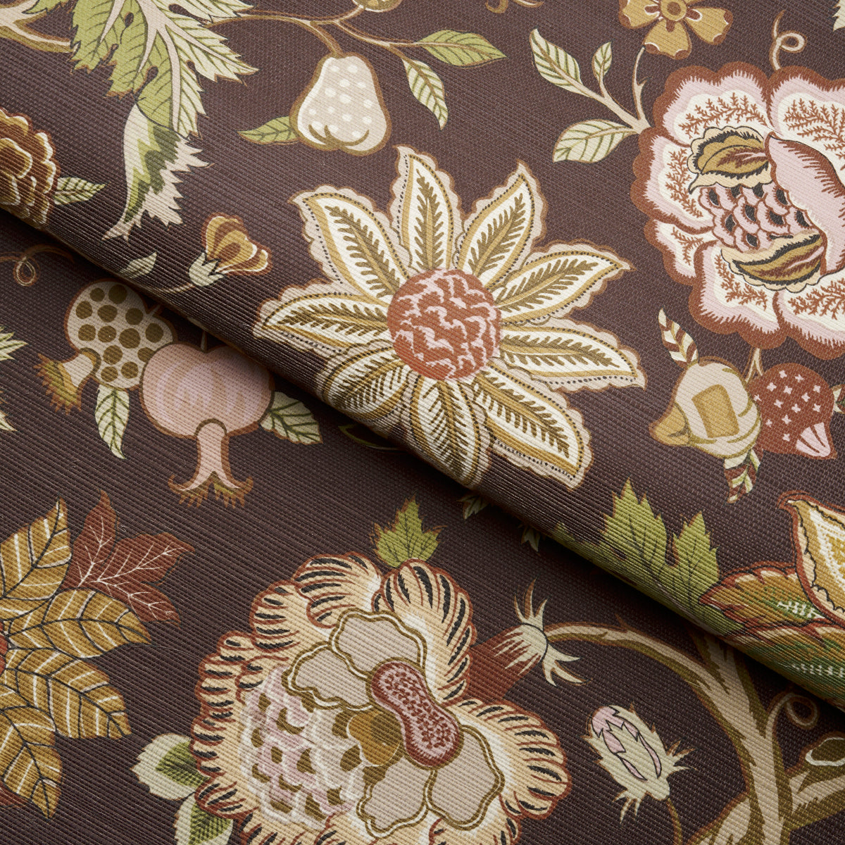 Brown floral fabric with large cream and yellow flowers, pink centers, and green leaves; folded corner.
