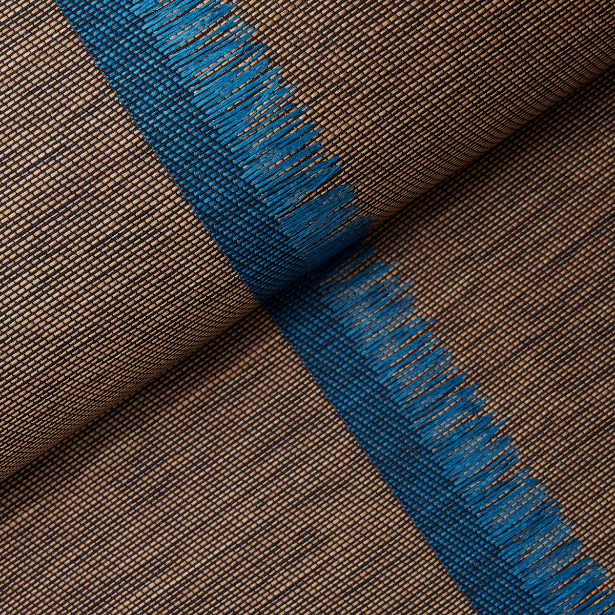 Brown woven fabric with a vibrant blue stripe and fringed edges, close-up roll.