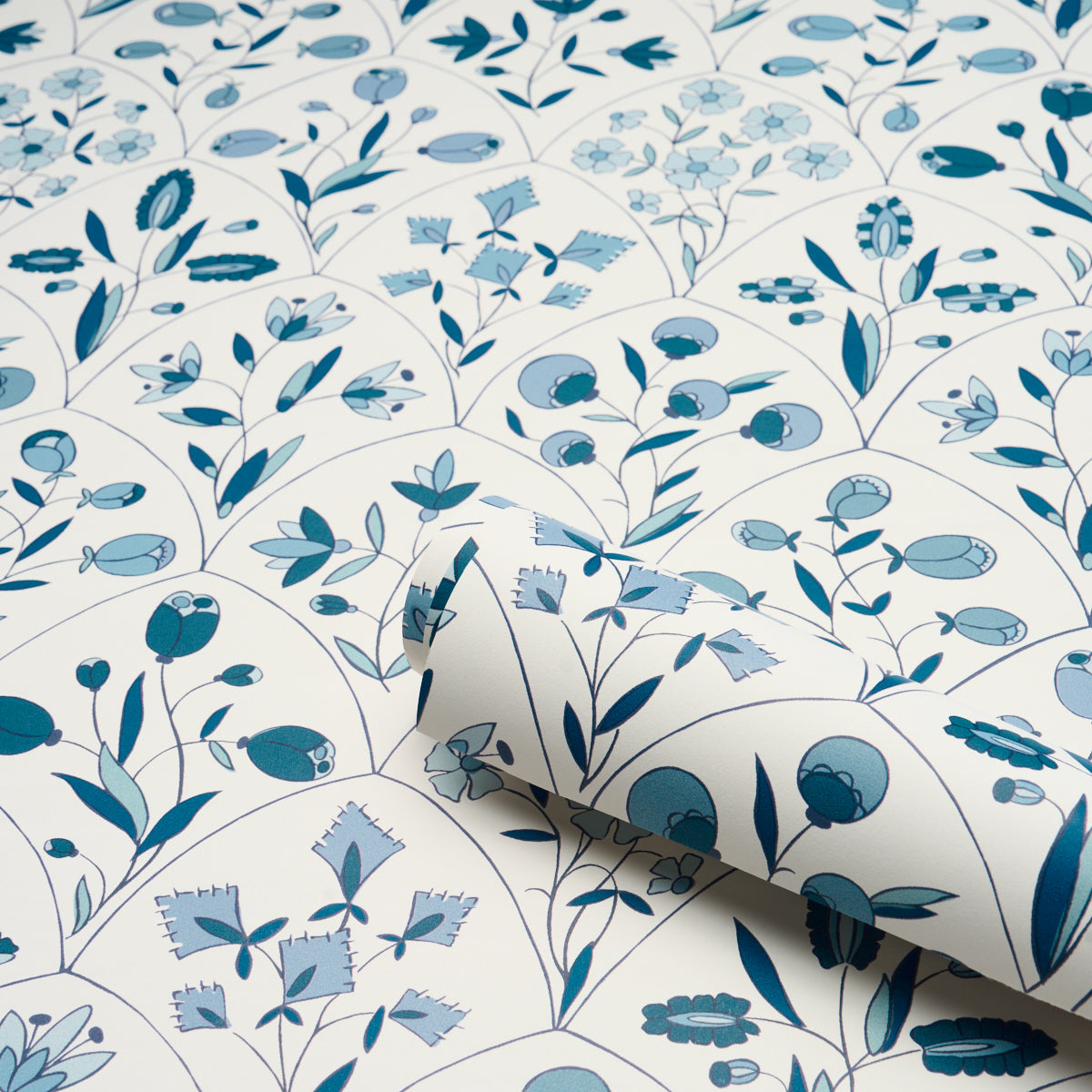 Blue botanical pattern with leaves and small flowers in circular motifs on white background; wallpaper or fabric.