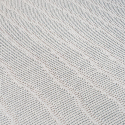 Close-up of a Whisper Blue wallcovering with a textured, raised wavy rib pattern.