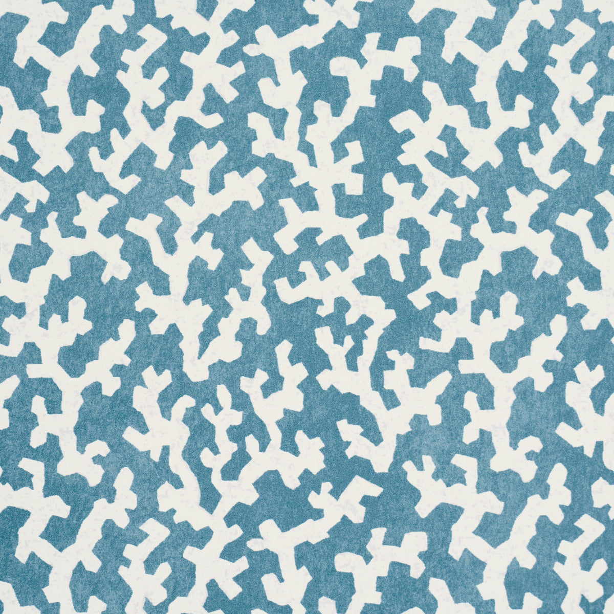 Blue fabric with a repeating white abstract cross-like pattern; modern textile print.