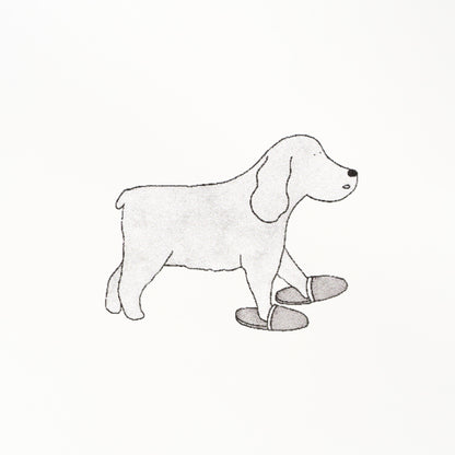 Gray sketch-style dachshund with floppy ears, standing, with a pair of slippers in front.