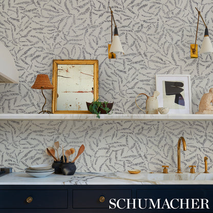 Kitchen with charcoal leaf bloom wallpaper, white marble counter, navy cabinets, gold faucet, pendant lights, and art frames.