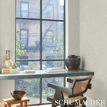 Industrial-style home office with blue-gray desk, black metal frame, rattan-backed chair, vase, books, and a large window.