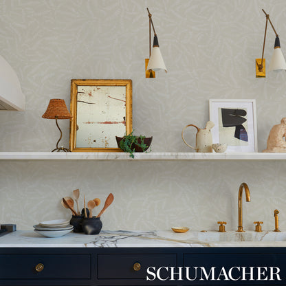 Modern kitchen with marble counter, navy cabinets, brass faucet, framed art, ceramic teapots and utensils under pendant lights.
