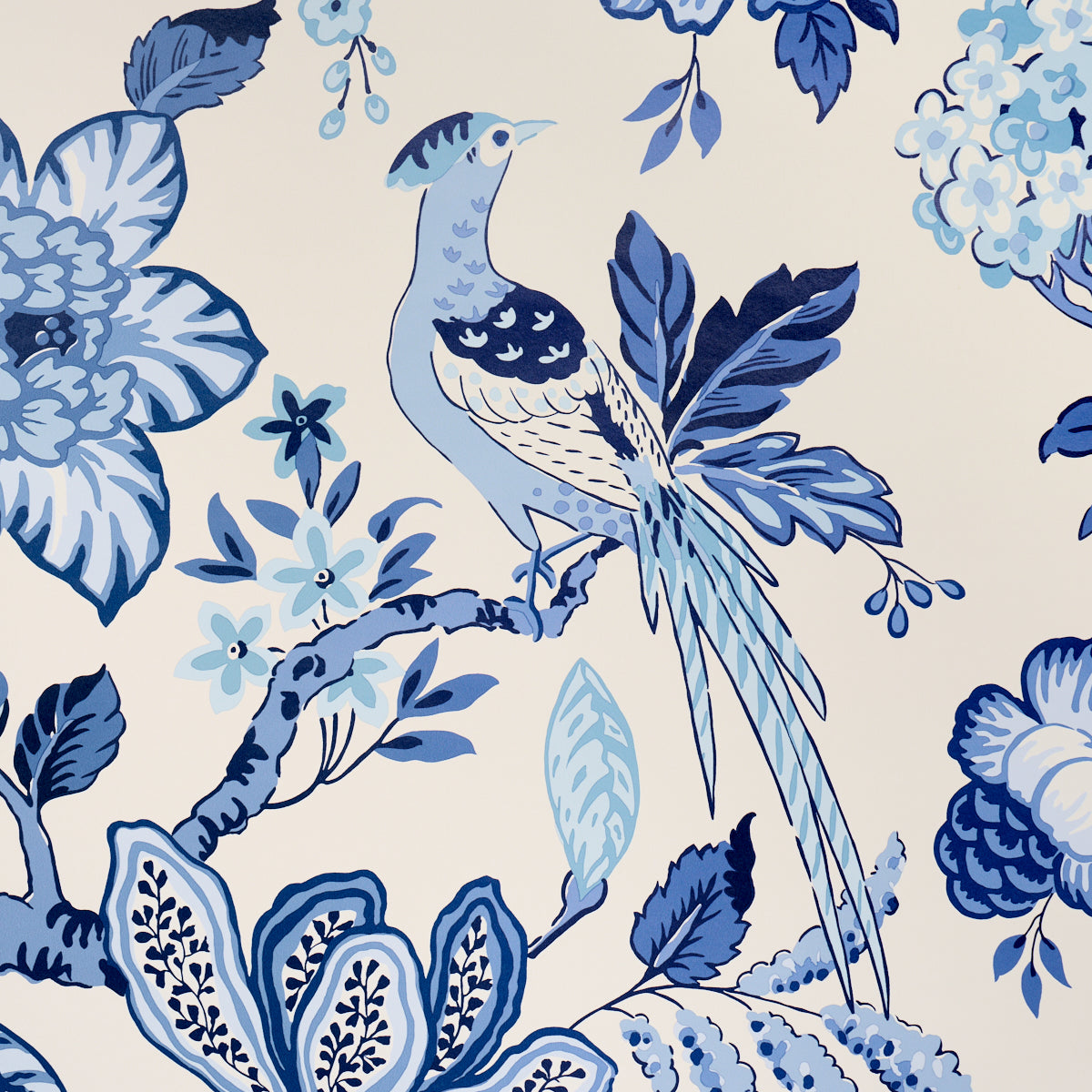 Blue and navy bird perched among stylized cream flowers and leaves in a toile-style fabric print.