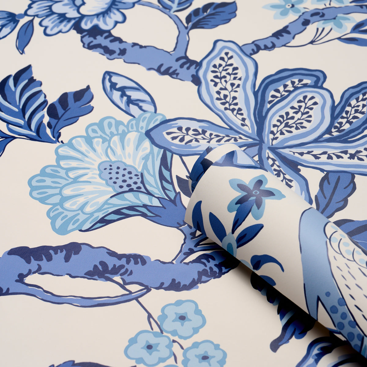 Blue and light-blue floral wallpaper on white; features large blossoms and leaves; rolled edge.
