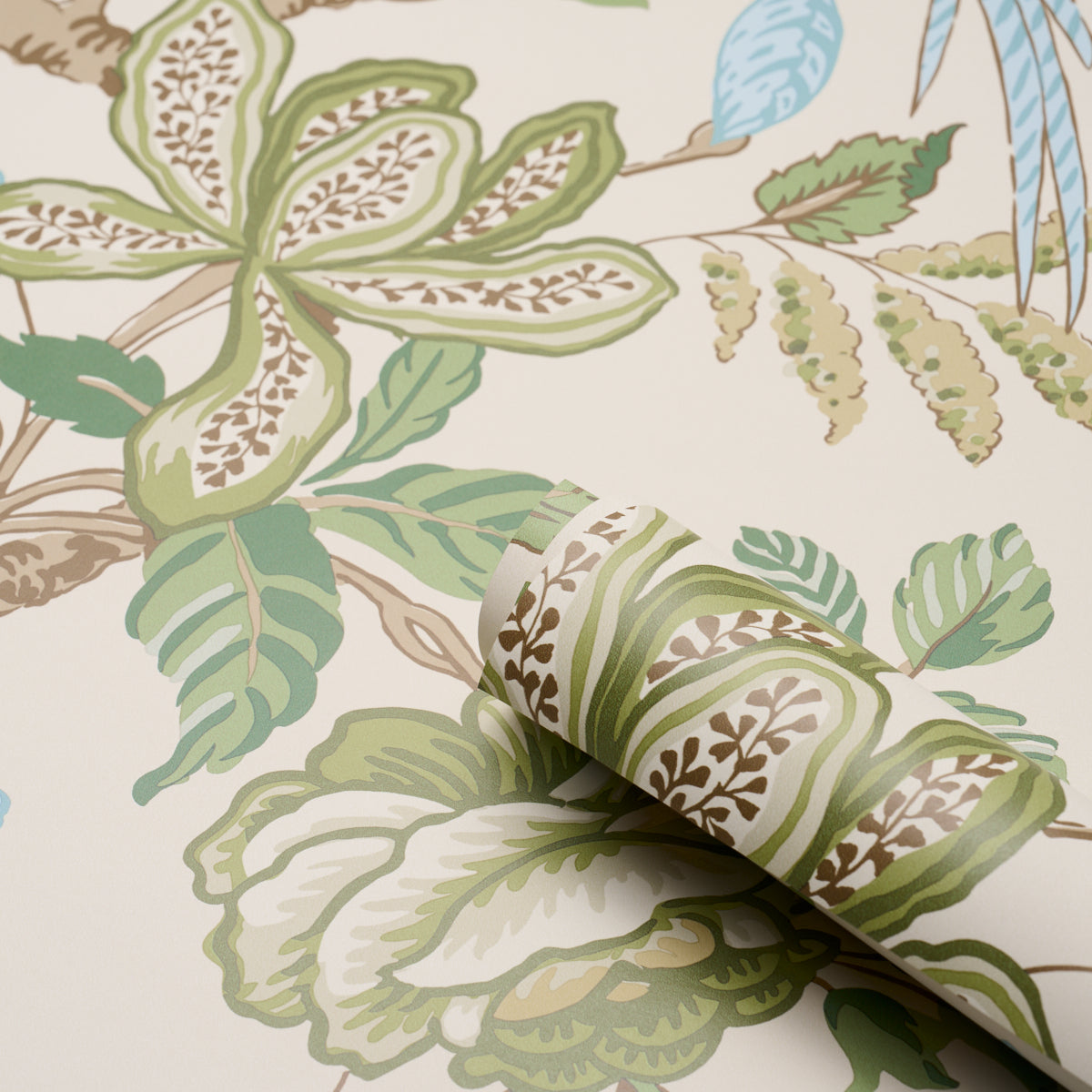 Botanical wallpaper roll featuring green, sage, and brown leaves on cream background; rolled edge shows pattern.