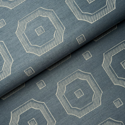 Blue fabric with white geometric octagon motifs and small square accents, folded to show repeating print.