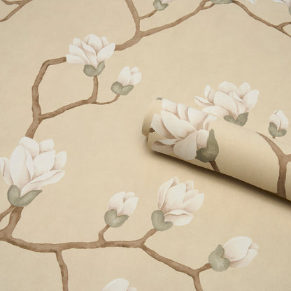 Beige wallpaper featuring brown branches with white magnolia blossoms; rolled sheet partially unrolled.