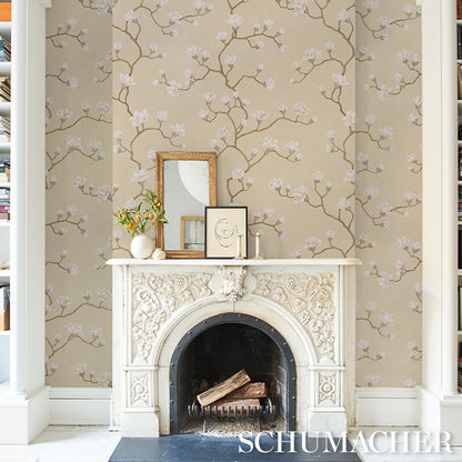 Beige wallpaper with pink blossom branches above a white ornate mantel in a bright living room.