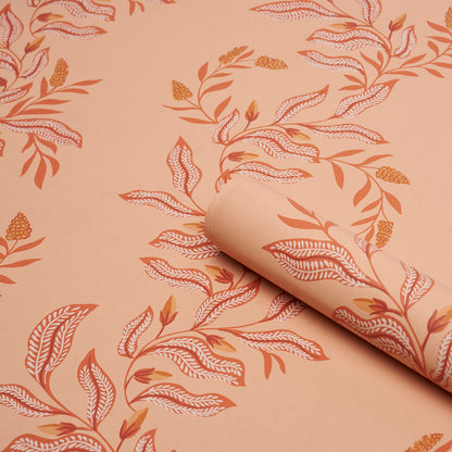 Peach wallpaper with orange botanical leaf pattern; rolled edge reveals seamless leaf design.