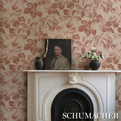 Cream mantel with black fireplace insert, floral wallpaper, framed portrait with a pearl necklace, black vases with flowers