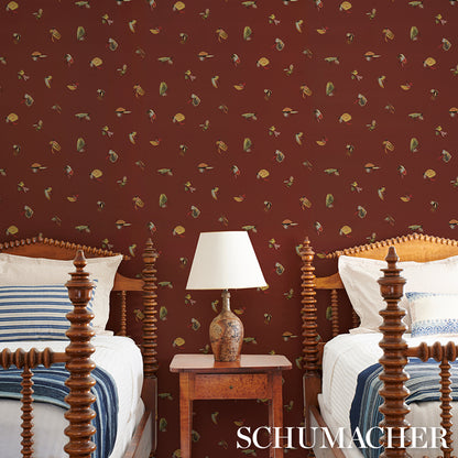 Ornate dark-wood four-poster beds with white linens and blue striped throws, carved bedside table and lamp, maroon wallpaper.