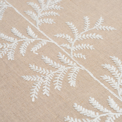 Beige linen fabric with white embroidered fern leaf pattern, botanical textile design.