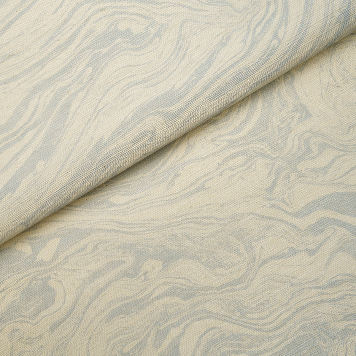 Beige fabric with pale blue marble-like swirl pattern and soft textile texture.