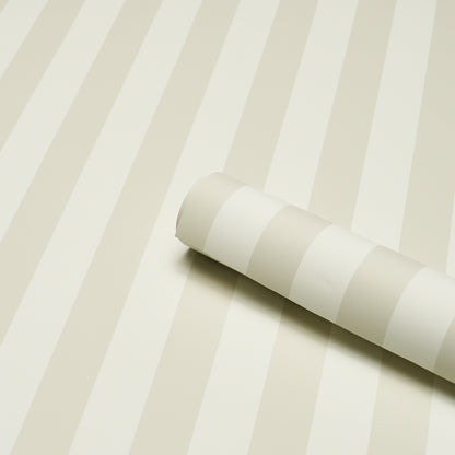 Rolled wallpaper sample with ivory and cream stripes on a beige striped wallpaper backdrop.
