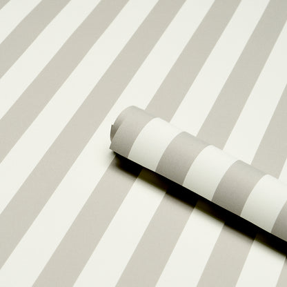 Gray and white striped wallpaper roll on a matching striped surface.