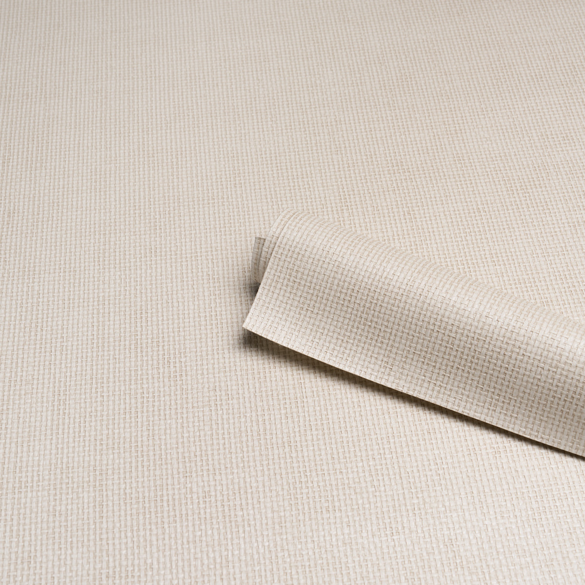 Beige linen-textured paperweave vinyl wallpaper roll on a neutral background, with a curved edge.