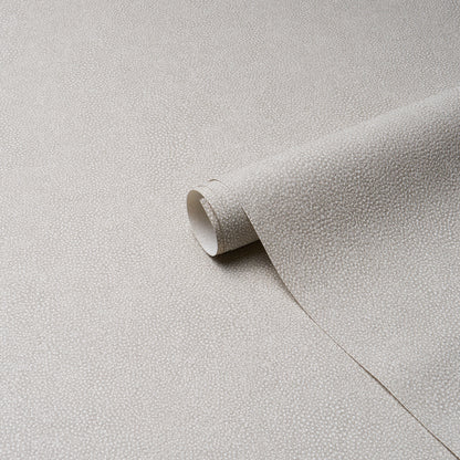 Beige dove textured vinyl with a tiny dot pattern and a rolled sheet visible for upholstery or drapery.
