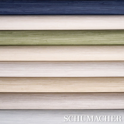 Stacked wallpaper swatches with linen texture in navy, ivory, sage green, beige, taupe, pale blue; Schumacher.