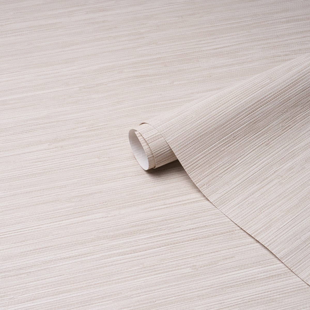 Beige wood-grain wallpaper roll, curled edge, partially unrolled on a light wooden surface.