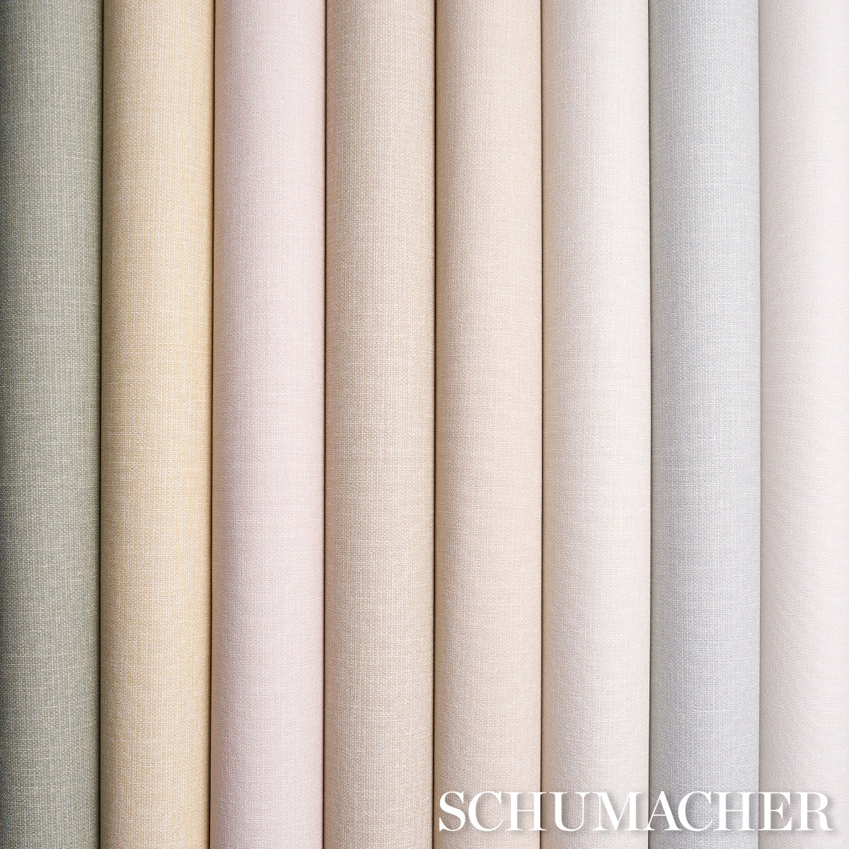 Row of vinyl sample rolls with a linen-textured surface in soft neutral pastels and creams, from green to grey.