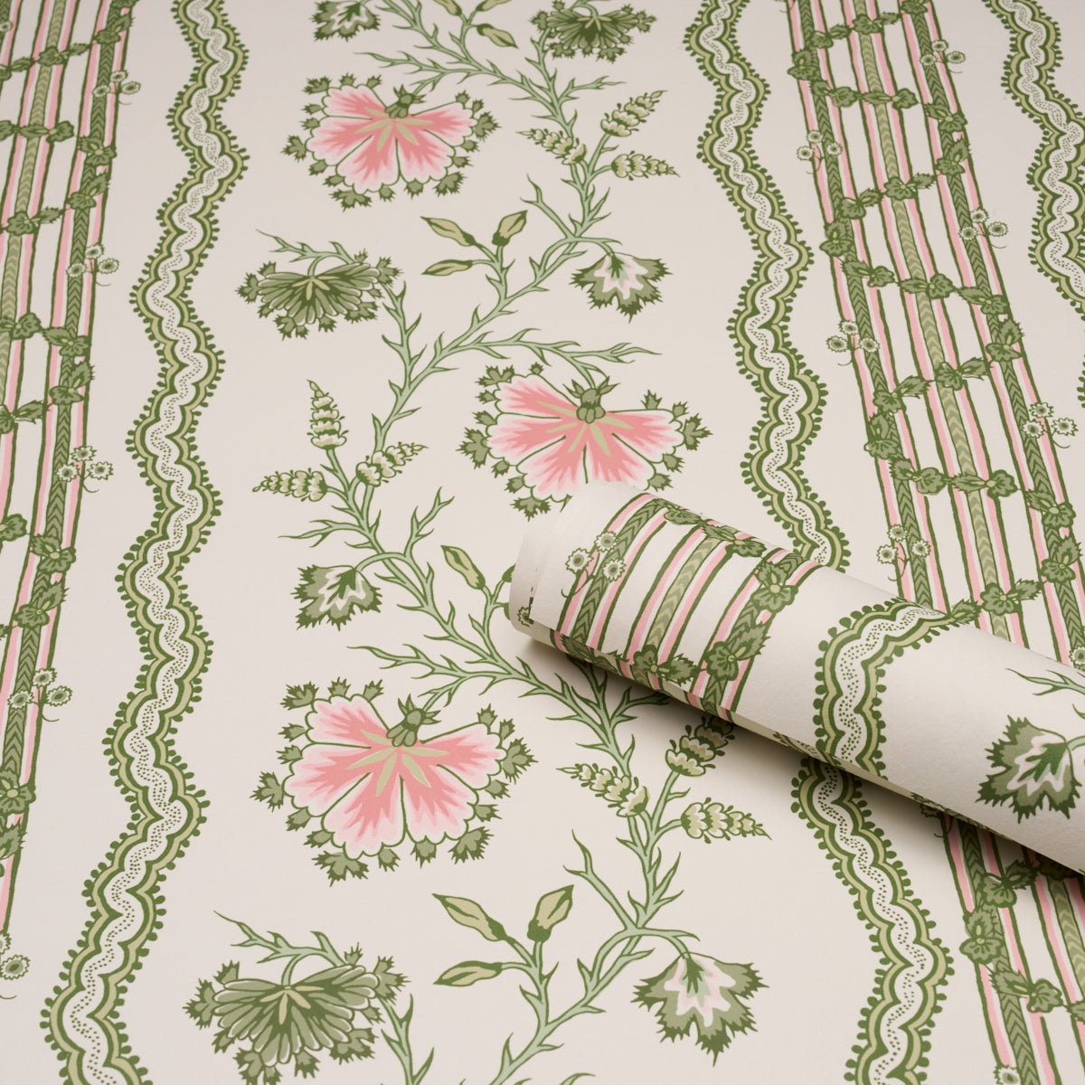 Cream floral wallpaper with pink flowers, green vines, and decorative green striped borders; rolled corner reveals pattern.