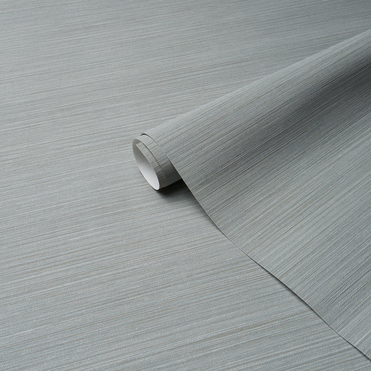 Grey metallic brushed-texture vinyl wallpaper roll, partially unrolled with subtle horizontal grain.