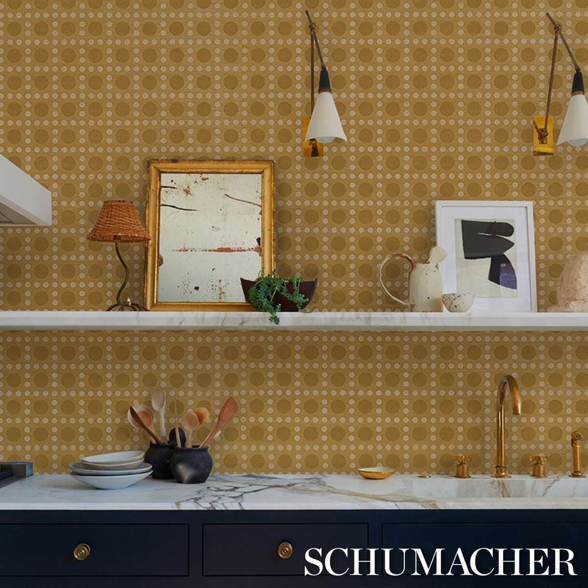 Navy cabinets with marble countertop, gold hardware, yellow geometric wallpaper; white shelves hold ceramic teapots and vases.