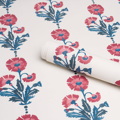 Roll of wallpaper featuring dianthus flowers in indigo tones with blue leaves against a white backdrop; bold botanical pattern.