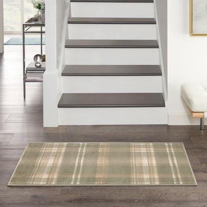 Green plaid area rug on dark wood floor beside white staircase with dark-tread steps and a modern entry bench.