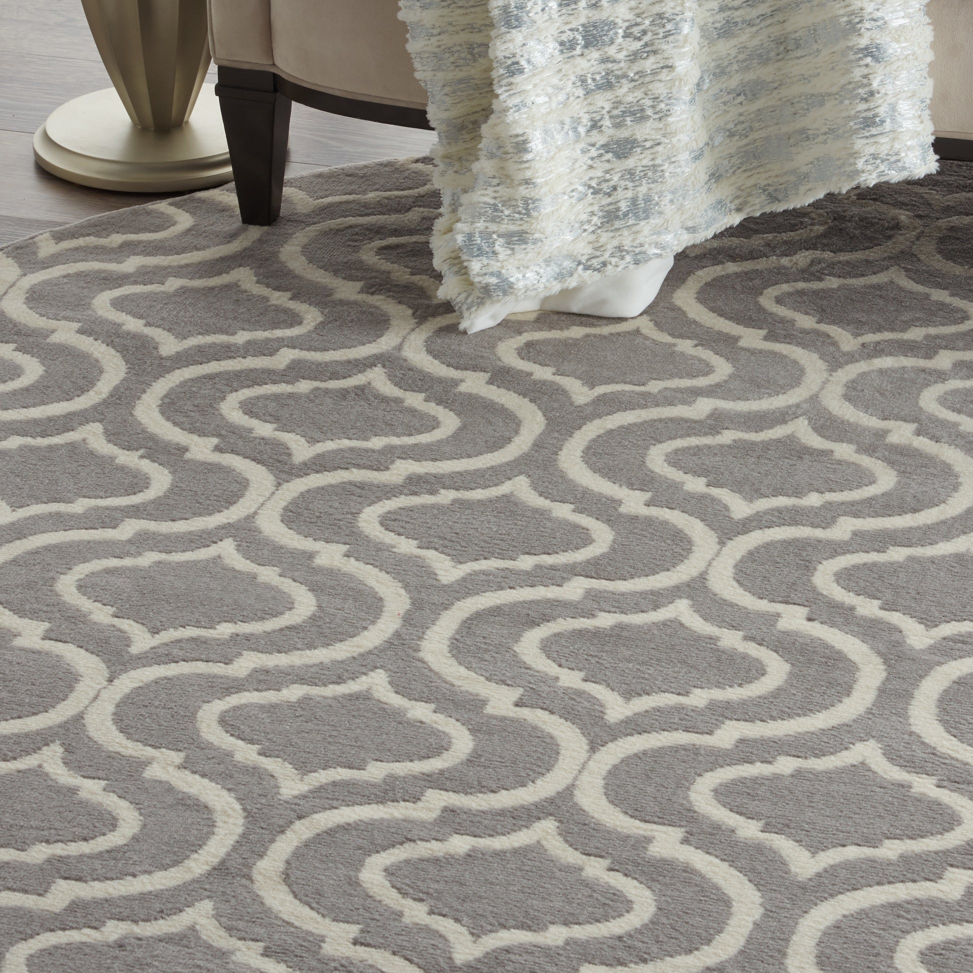 Gray & cream trellis-pattern round area rug with soft pile in a living room setting