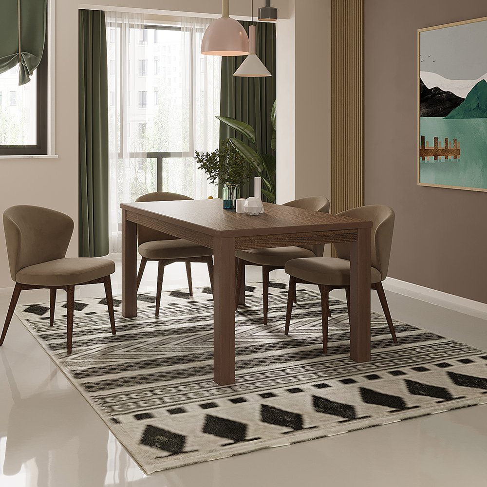Wooden dining table with taupe chairs on a black-and-white geometric rug, green curtains, and pendant lights.