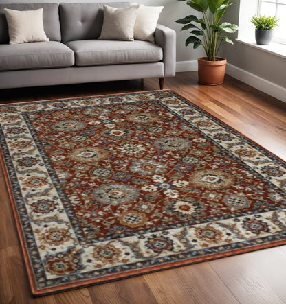 5' X 8' Red Blue Ivory Gold And Navy Oriental Power Loom Stain Resistant Area Rug With Fringe