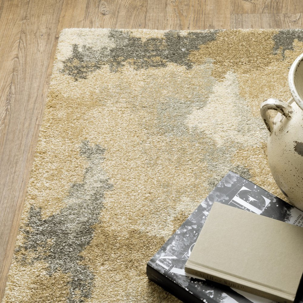 5' X 8' Beige Grey And Gold Abstract Power Loom Stain Resistant Area Rug