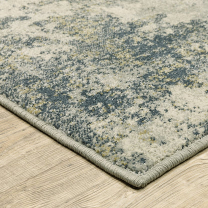 8' x 10' beige, teal, grey and gold abstract patterned rug with light gray edge binding on wood floor