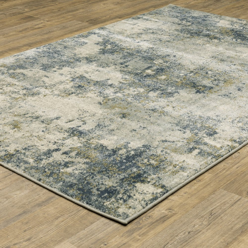 Rectangular abstract area rug in beige, teal, grey and gold tones; low-pile with bound edges, 8' x 10'; power-loomed and stain-resistant.