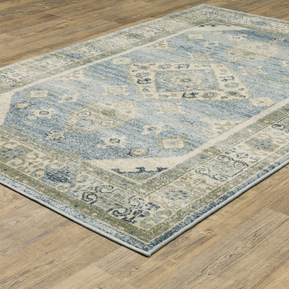 Blue and beige oriental rug with a central medallion and ornamental border on a wooden floor.