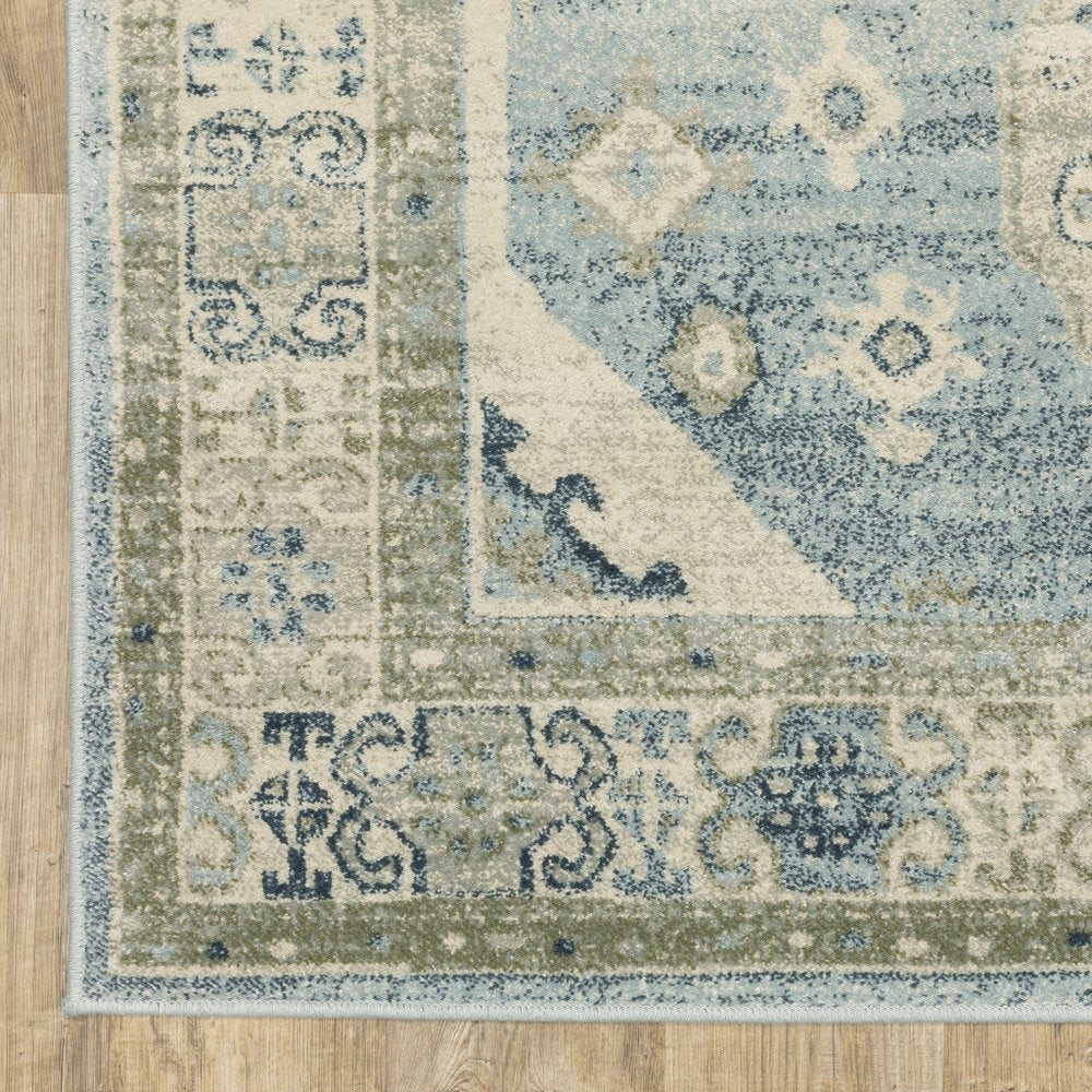 Distressed blue and beige oriental-style area rug with decorative border on wood floor.