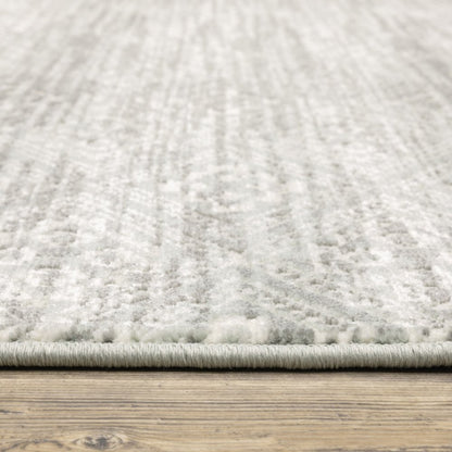Gray and ivory patterned rug with soft pile and bound edge on a wood floor.