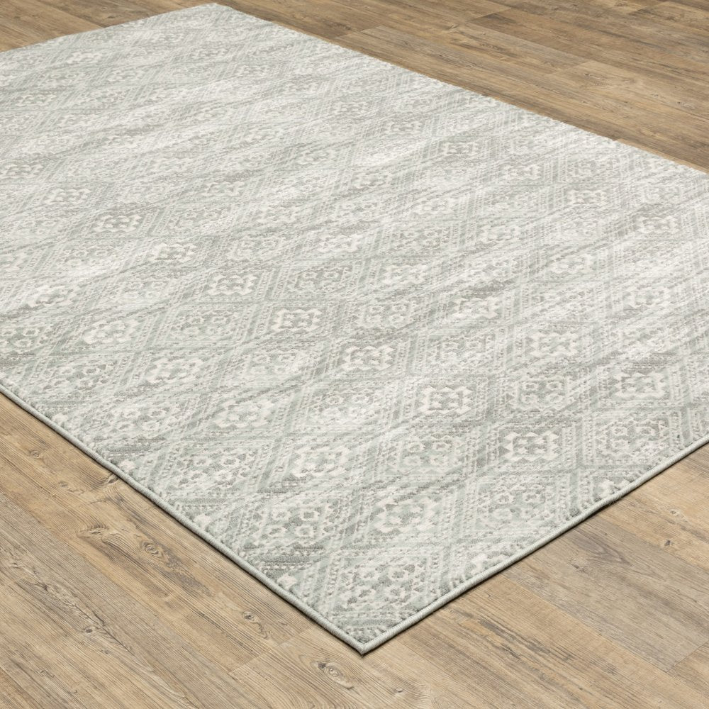 Soft light gray area rug with subtle diamond geometric pattern on wood floor.